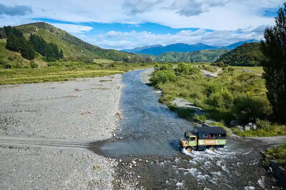 The truck crossing the wide stone river bed