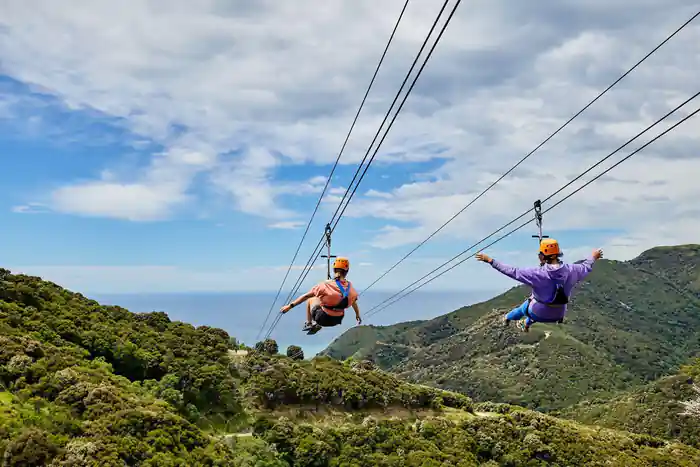 Two riders side by side on the dual lines above the sea